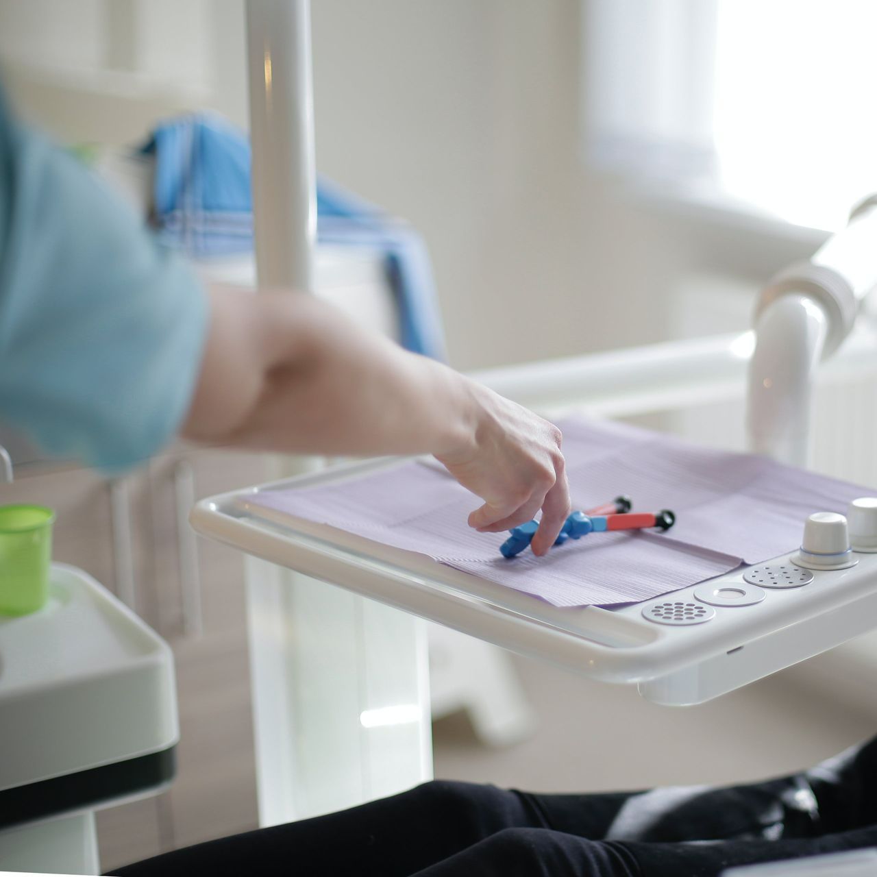 A person 's hand is reaching for a pen on a tray