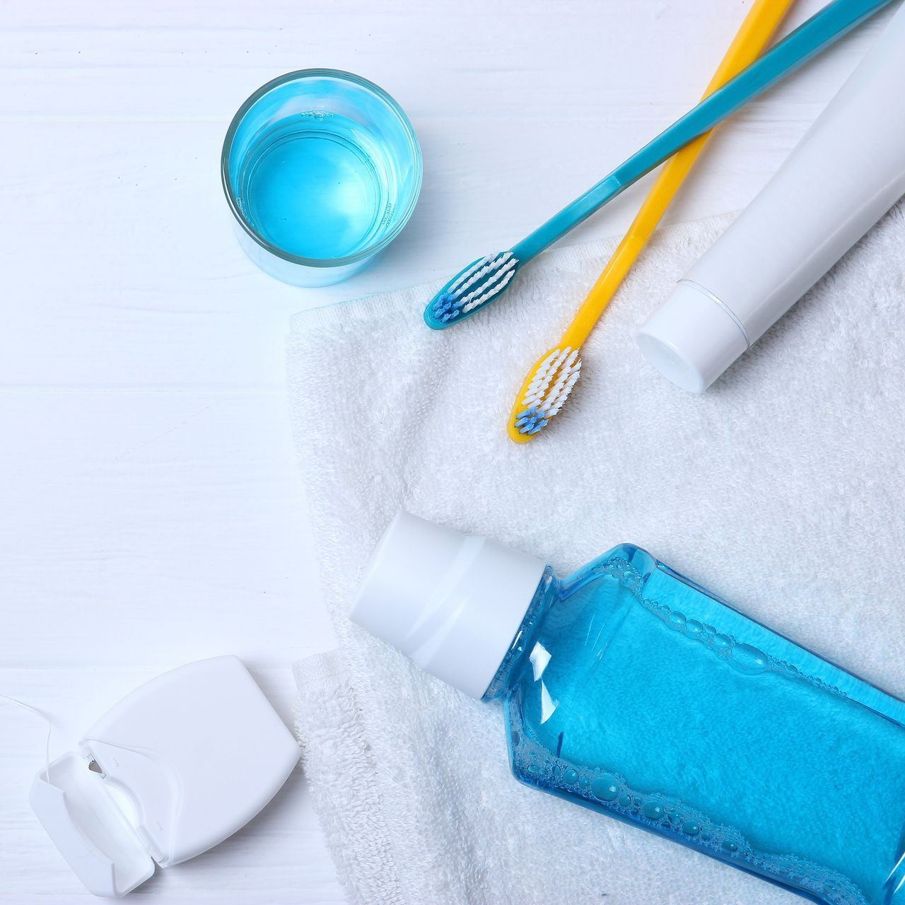 A bottle of mouthwash next to a toothbrush and toothpaste