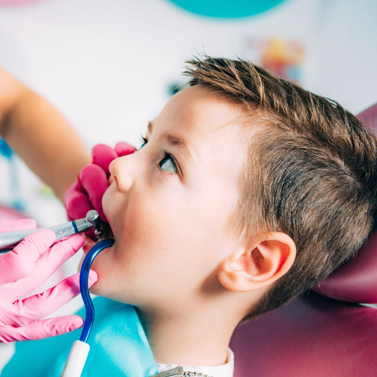 A young boy is getting his teeth examined by a dentist.