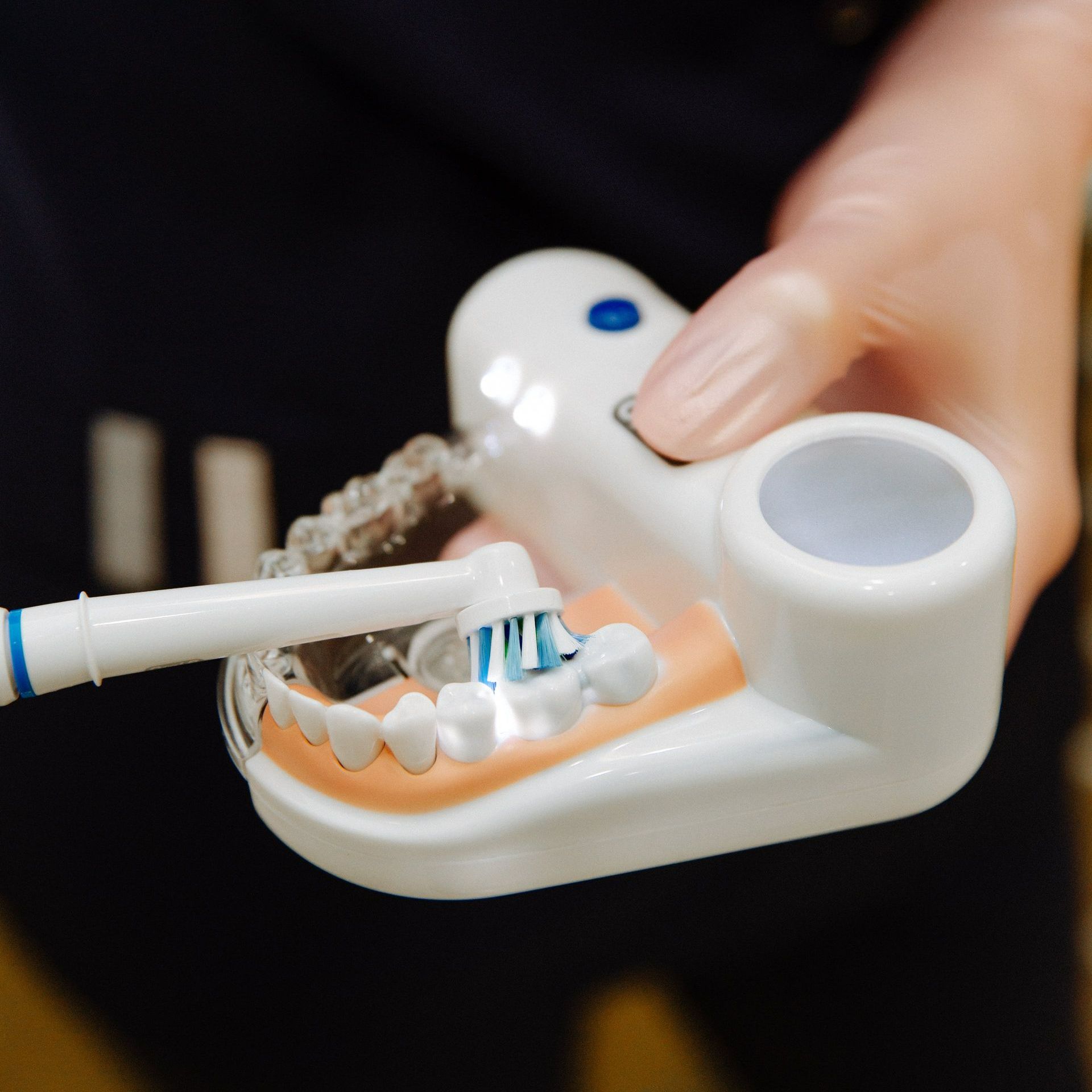 A person is brushing their teeth with an electric toothbrush