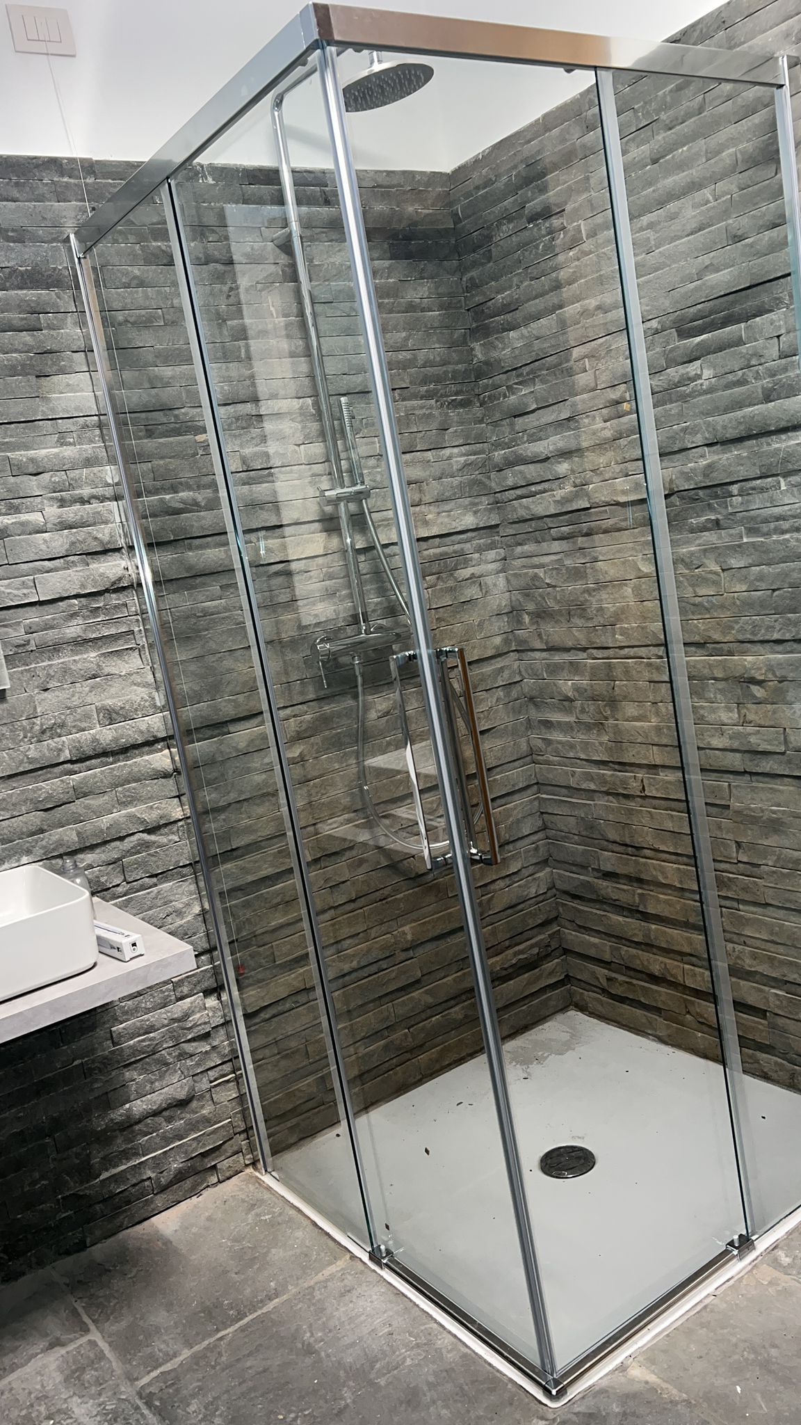 Un bagno con box doccia e lavandino.