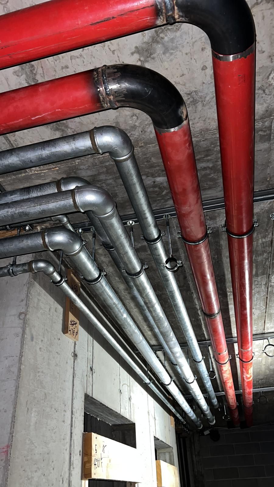 Un mucchio di tubi pendono dal soffitto di un edificio.