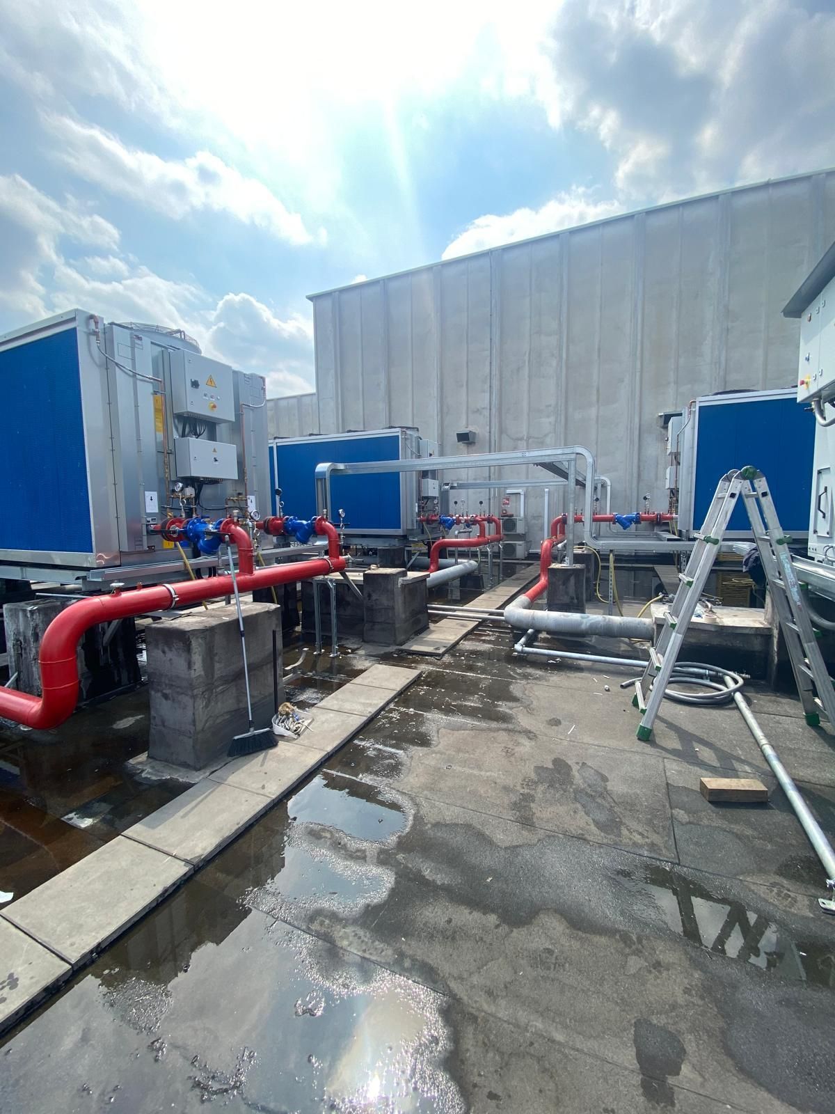 Un grande edificio con un sacco di tubi e una scala di fronte