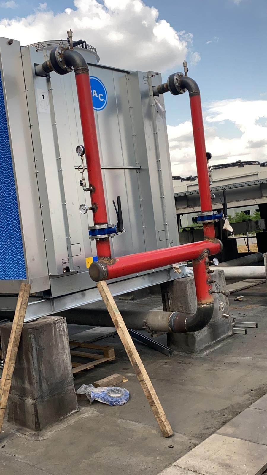 Una grande struttura metallica con tubi rossi attaccati.