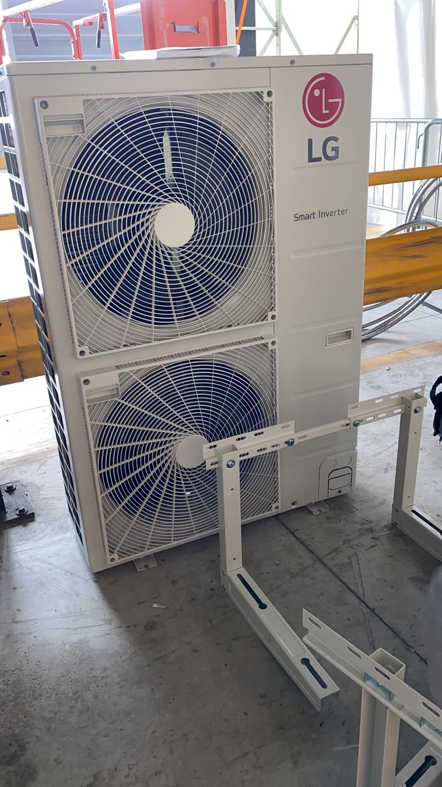 Un condizionatore LG è appoggiato sul pavimento di un magazzino.