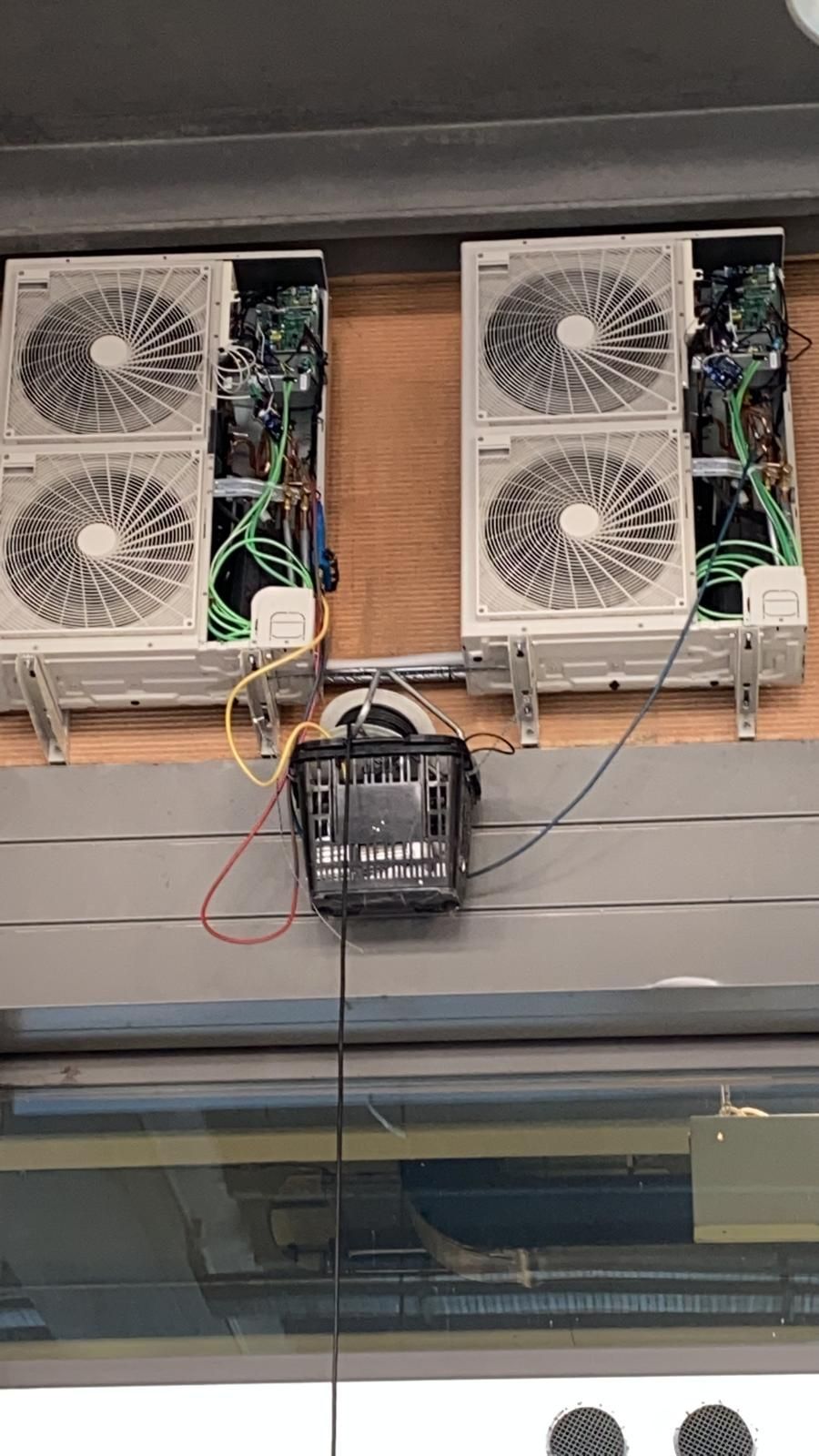 Un mucchio di condizionatori d'aria sono appesi al soffitto di un edificio.