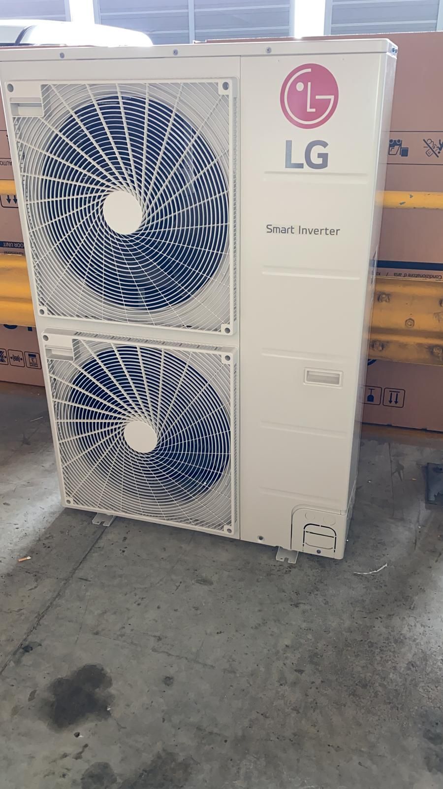 Un condizionatore LG è appoggiato a terra in un magazzino.
