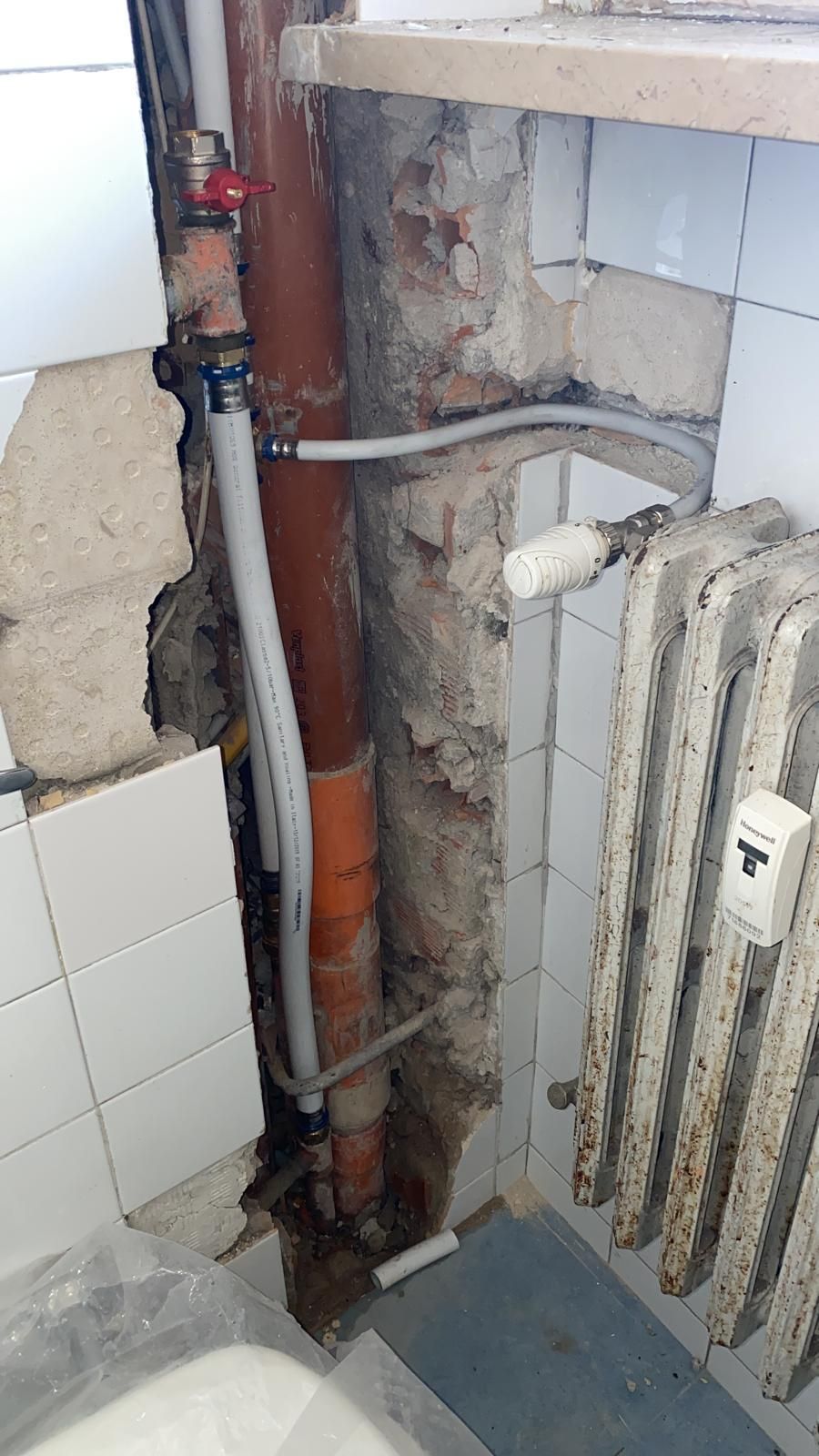 Un bagno con un buco nel muro e un termosifone.