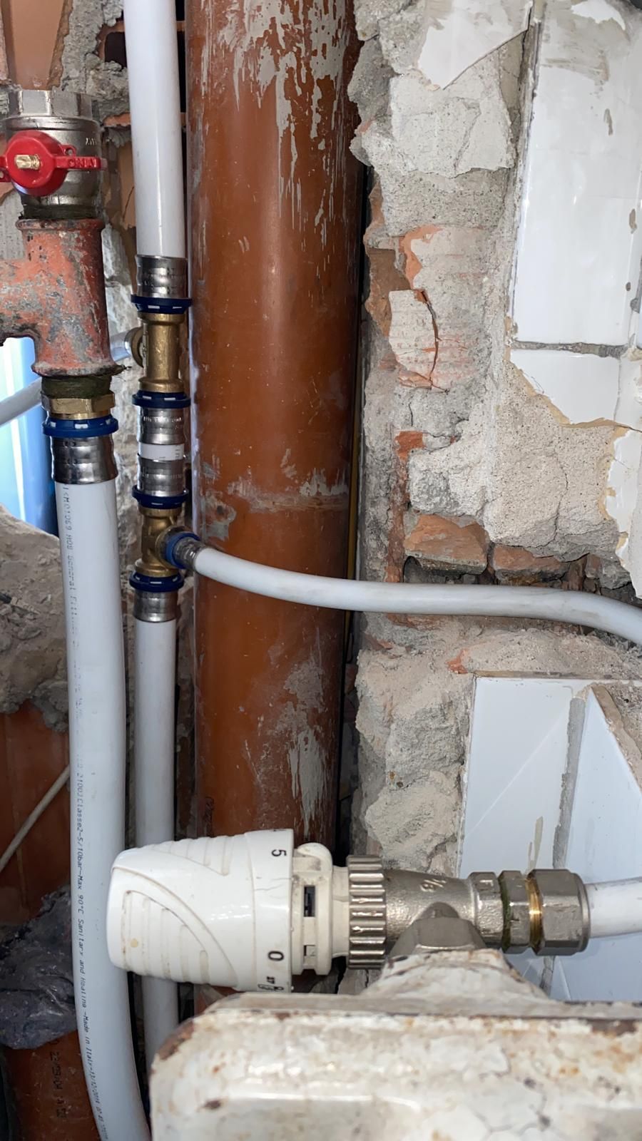 Primo piano di una valvola su un radiatore accanto a un tubo.