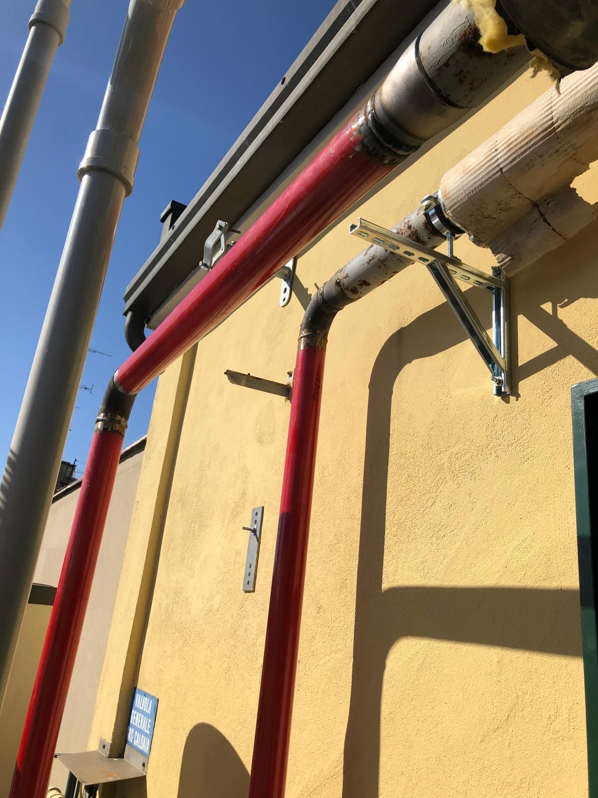 Un edificio giallo con un sacco di tubi sopra