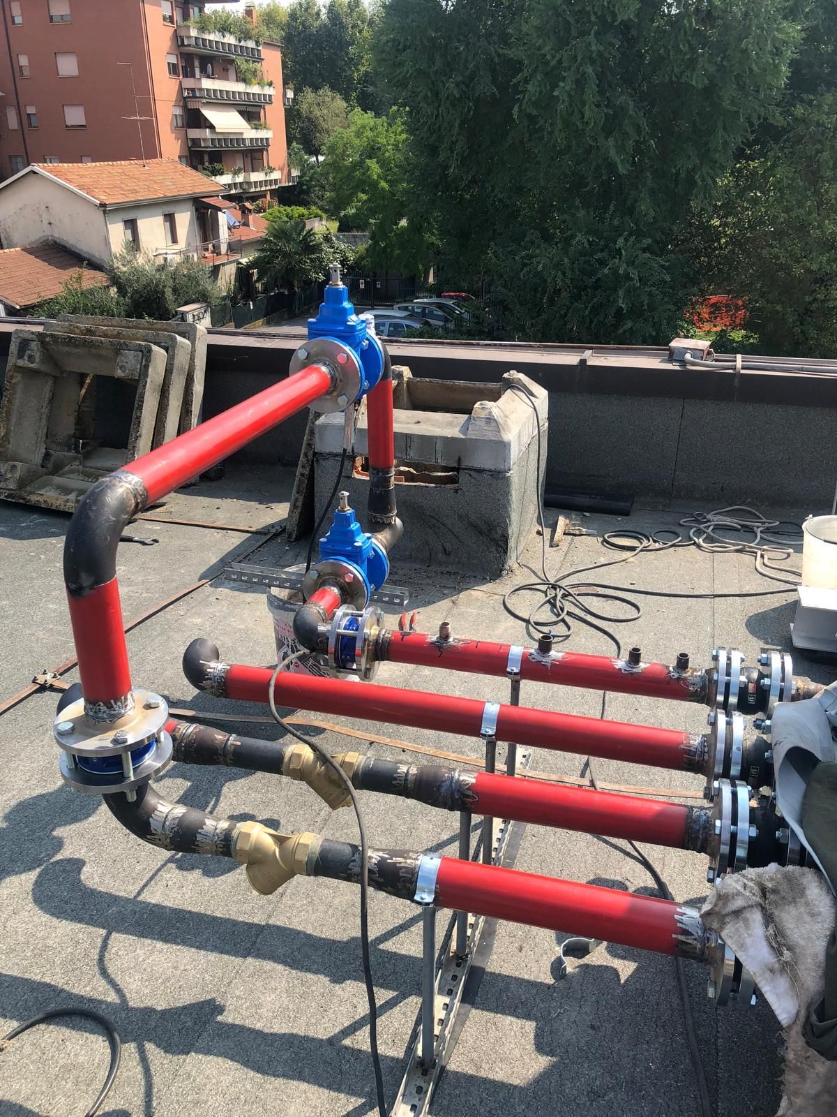 Una fila di tubi rossi è appoggiata sulla cima di un tetto.