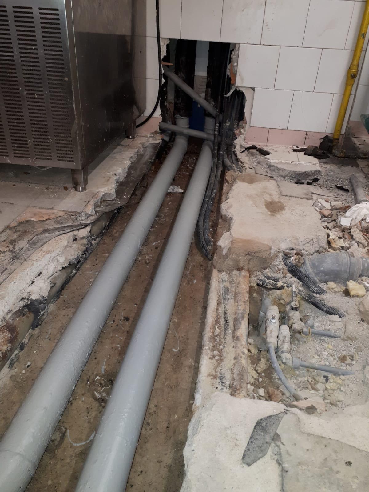 Un mucchio di tubi escono da un buco nel pavimento