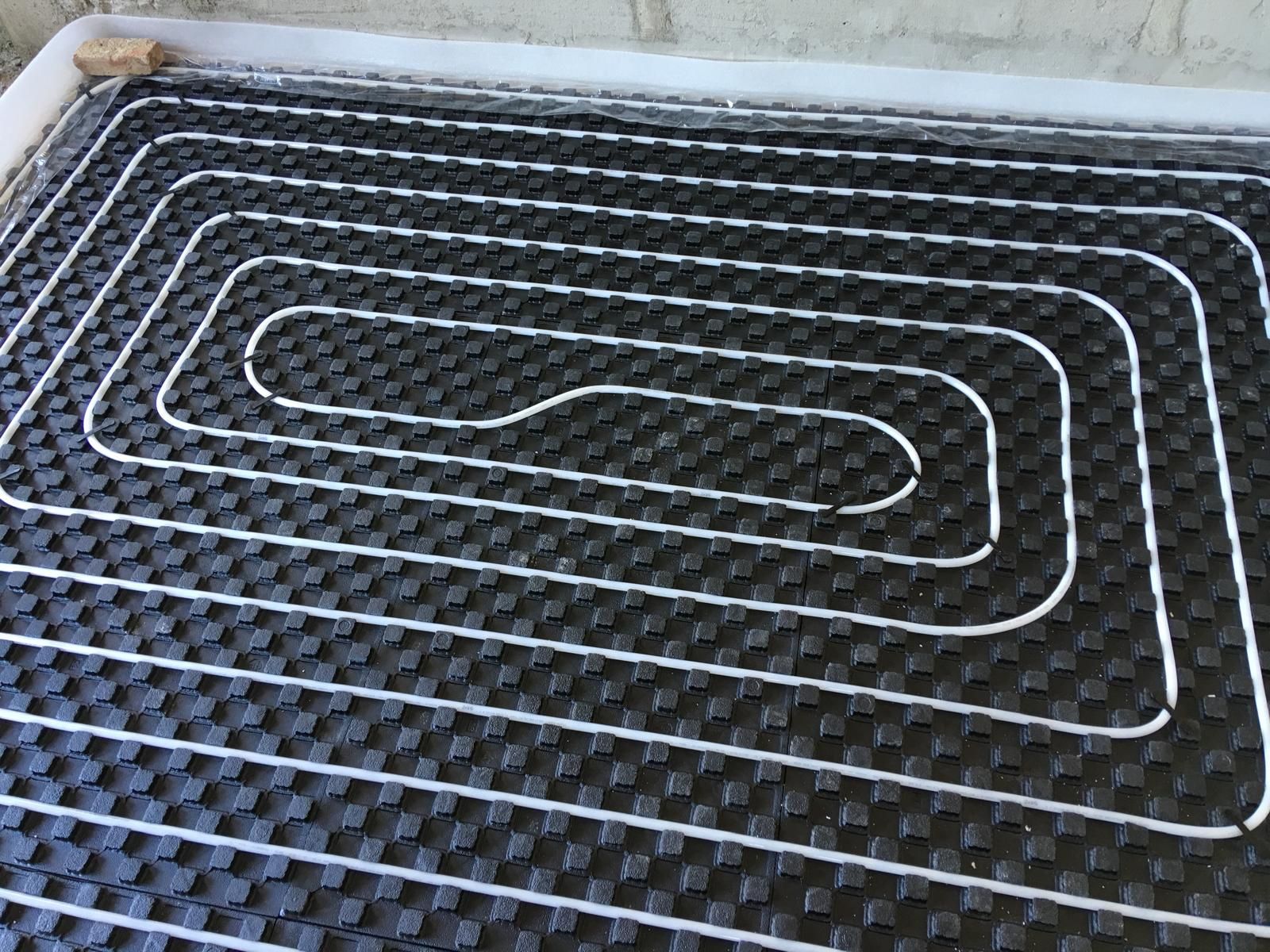 Un primo piano di un sistema di riscaldamento a pavimento su un pavimento.