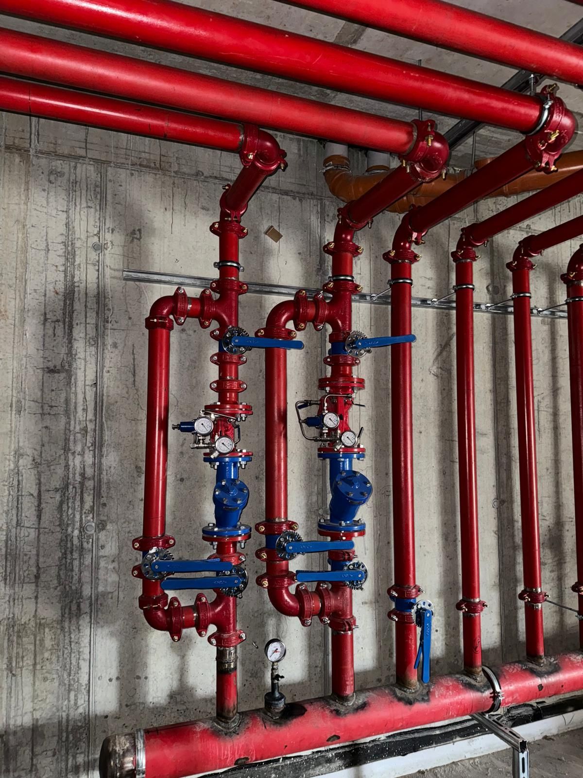 Un mucchio di tubi rossi pendono dal soffitto di un edificio.
