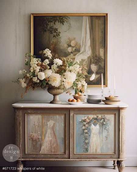 A dresser with a painting on it and a vase of flowers on top of it.