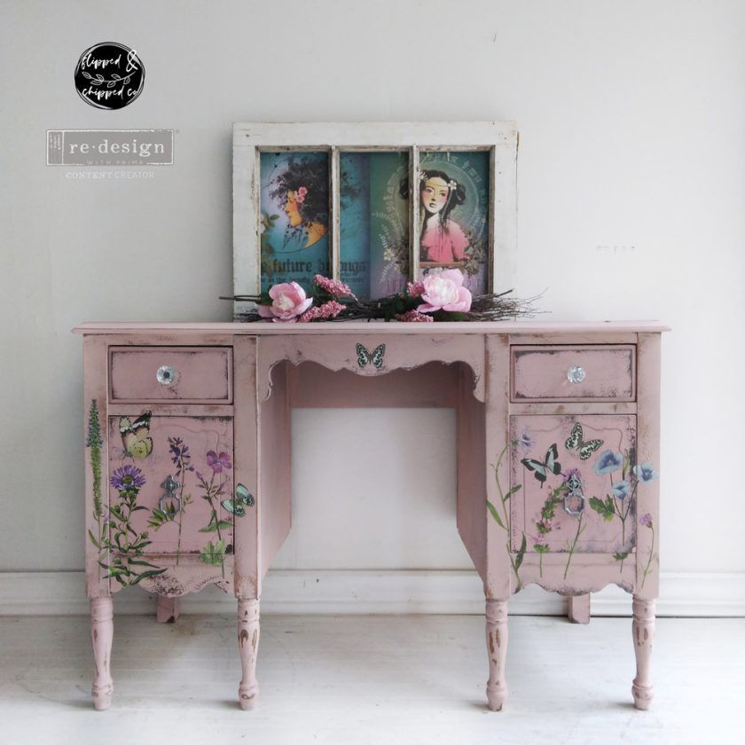 A pink desk with flowers and butterflies painted on it