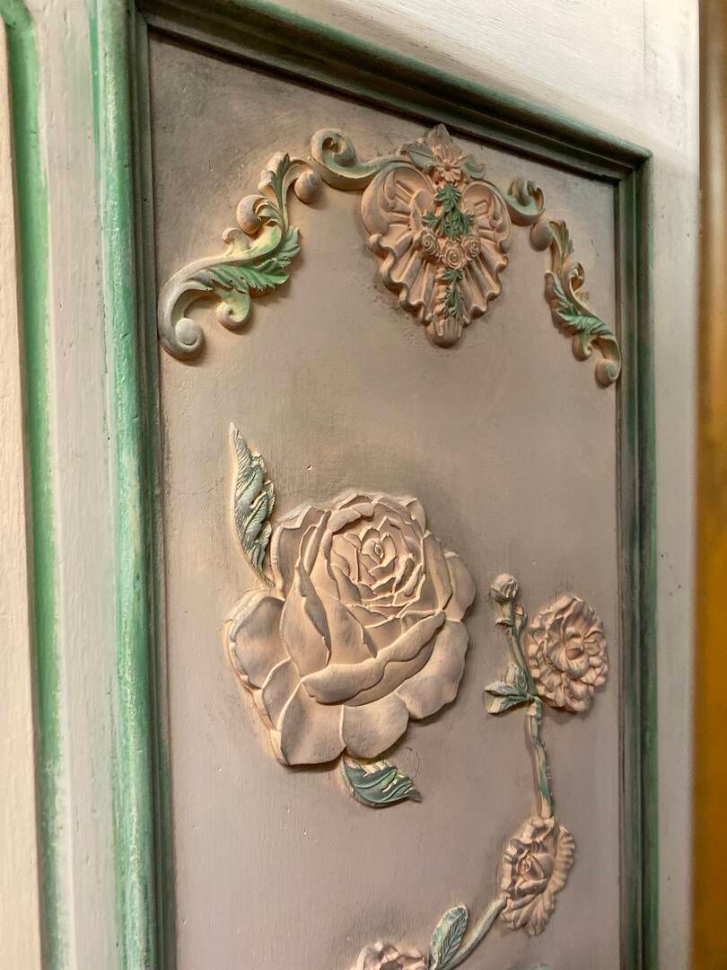 A close up of a painting of roses on a wall.