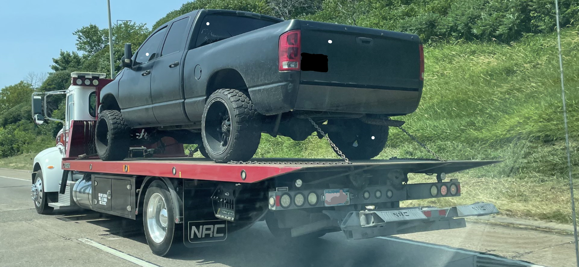 flat bed tow truck with a junk pick up truck