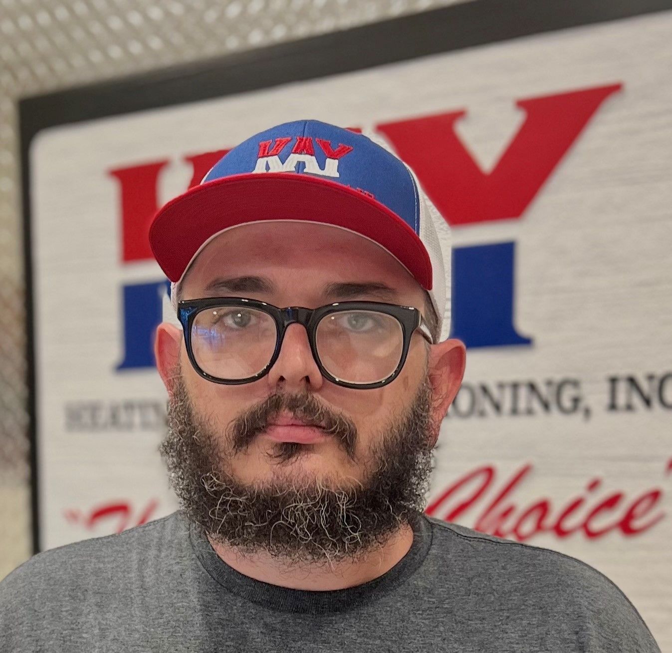 A man with a beard wearing a hat and glasses