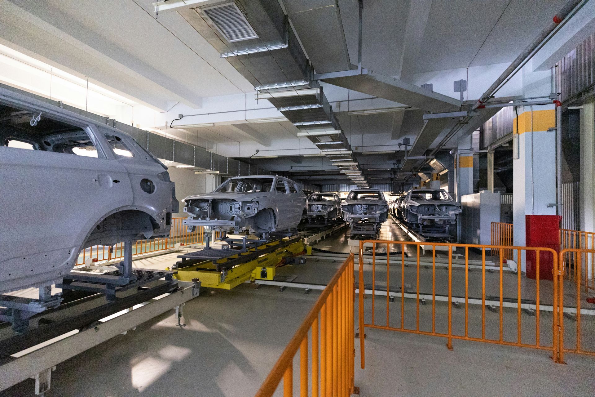A bunch of cars are sitting on a conveyor belt in a factory