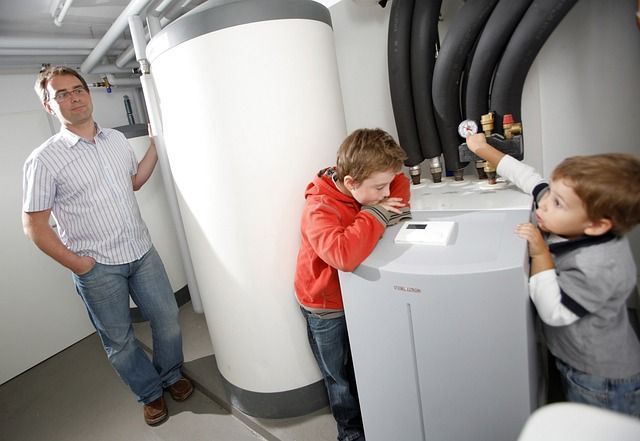 A man and two children are standing next to a heater.