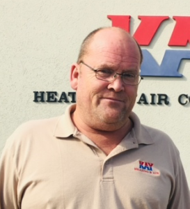 A man stands in front of a sign that says heat air