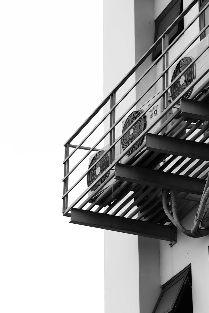 A black and white photo of a fire escape on the side of a building