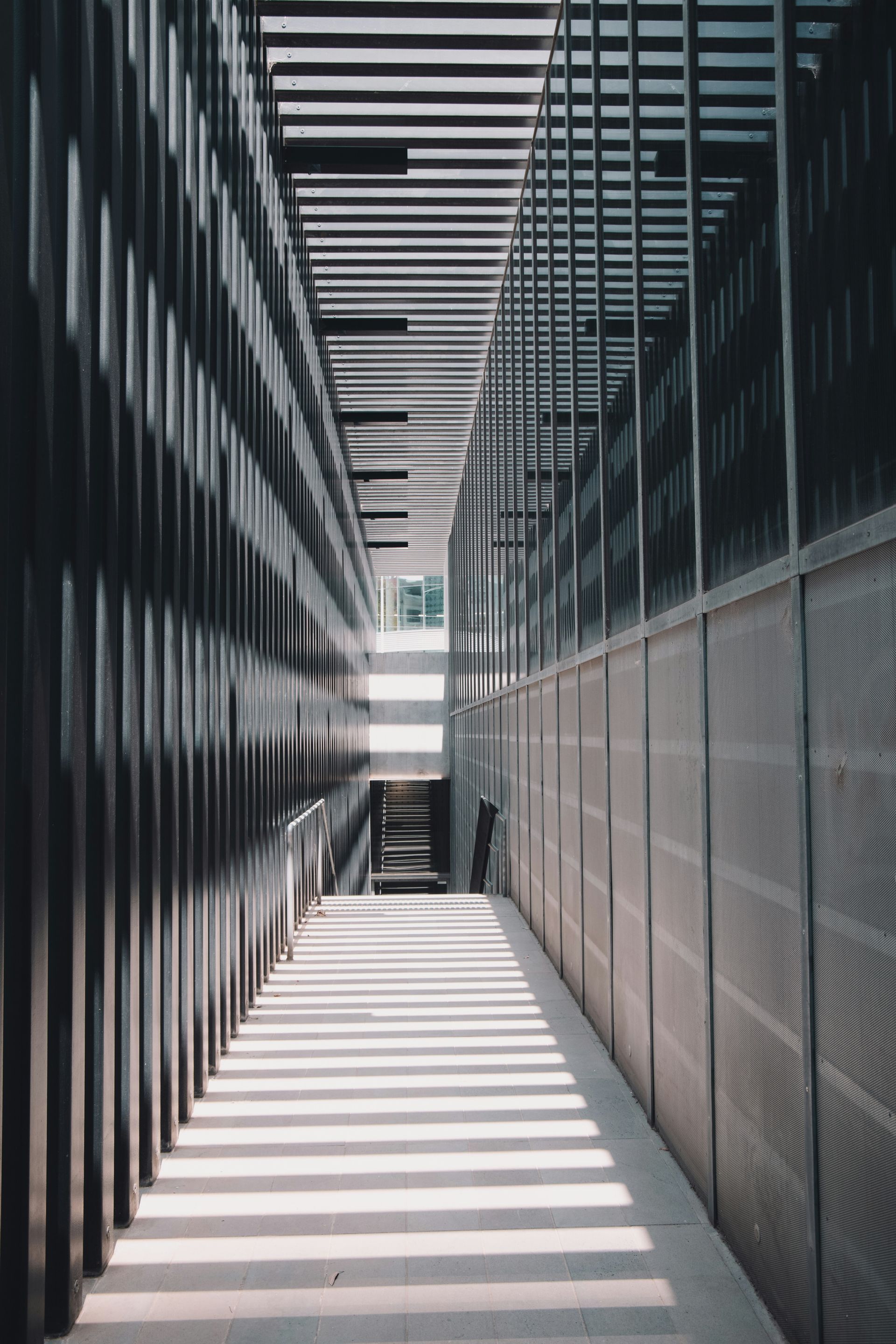 A black and white photo of a long hallway in a building.