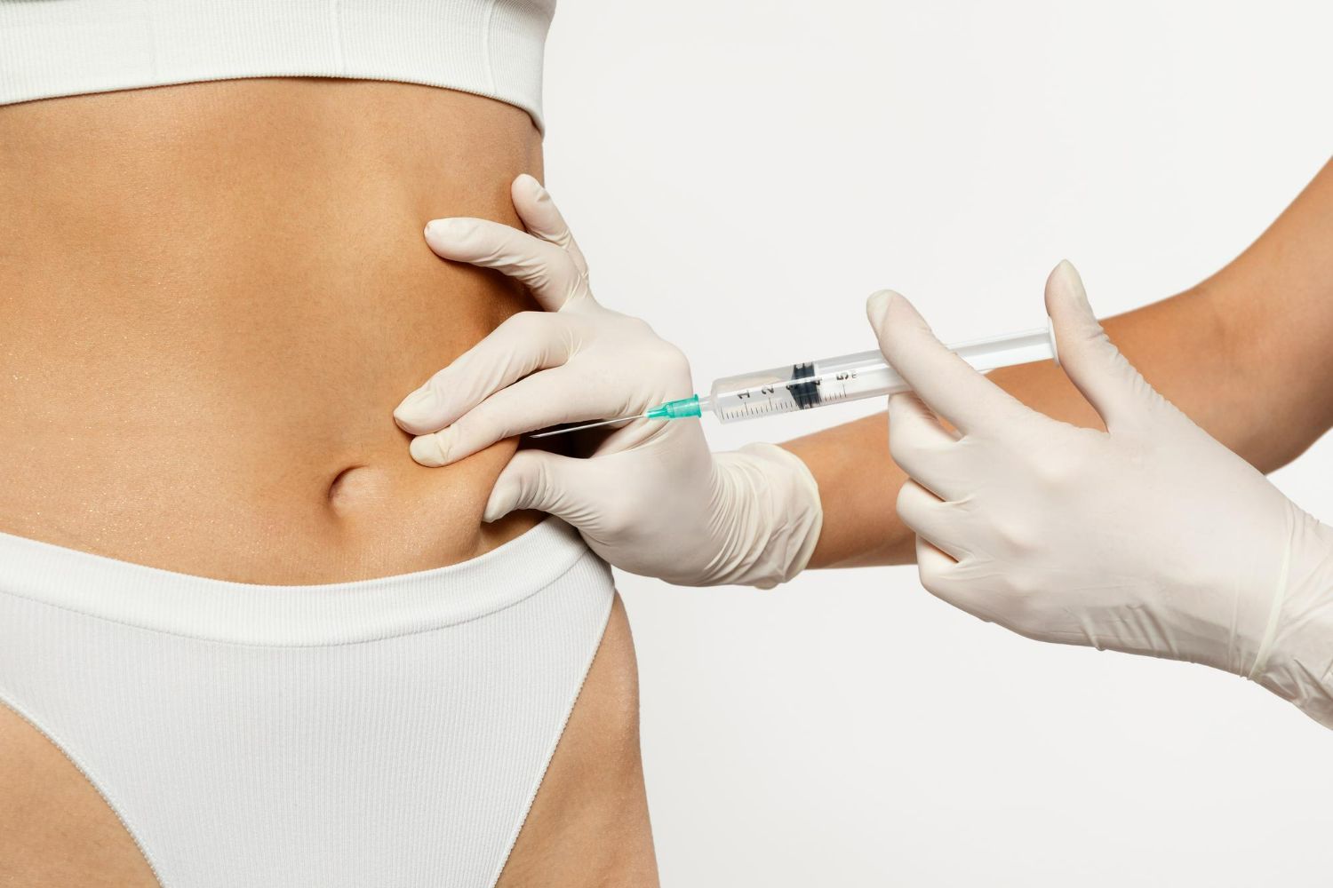 A woman is getting an injection in her stomach.