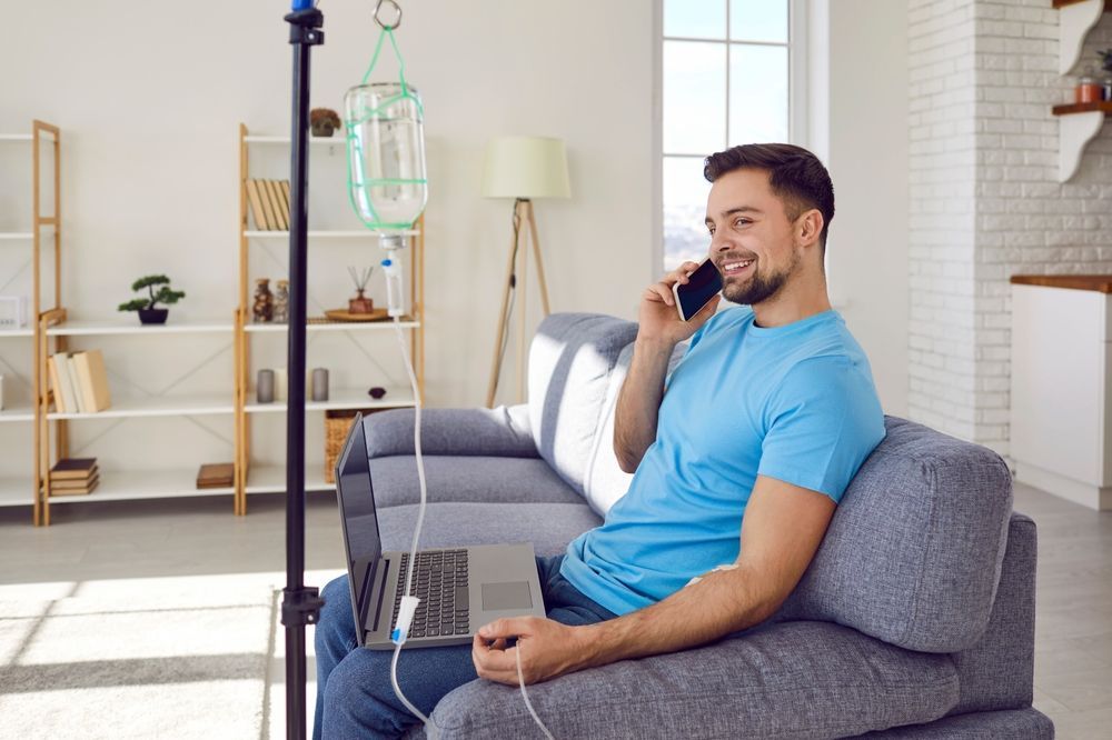 A man is sitting on a couch talking on a cell phone.