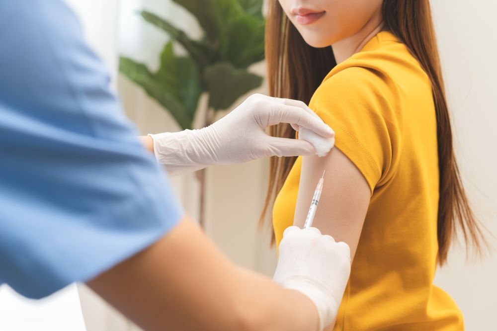 A woman is getting an injection in her arm.