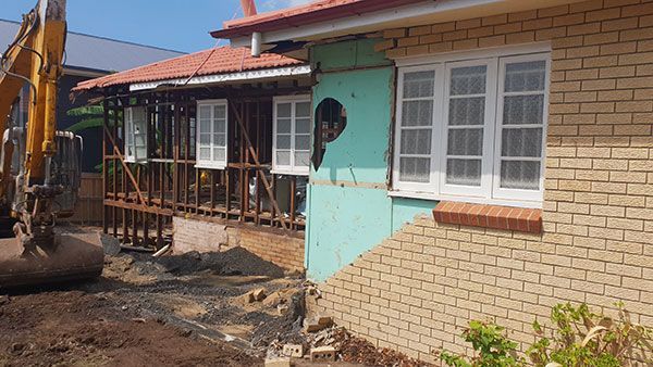 Two construction vehicles are parked next to each other on a dirt road.