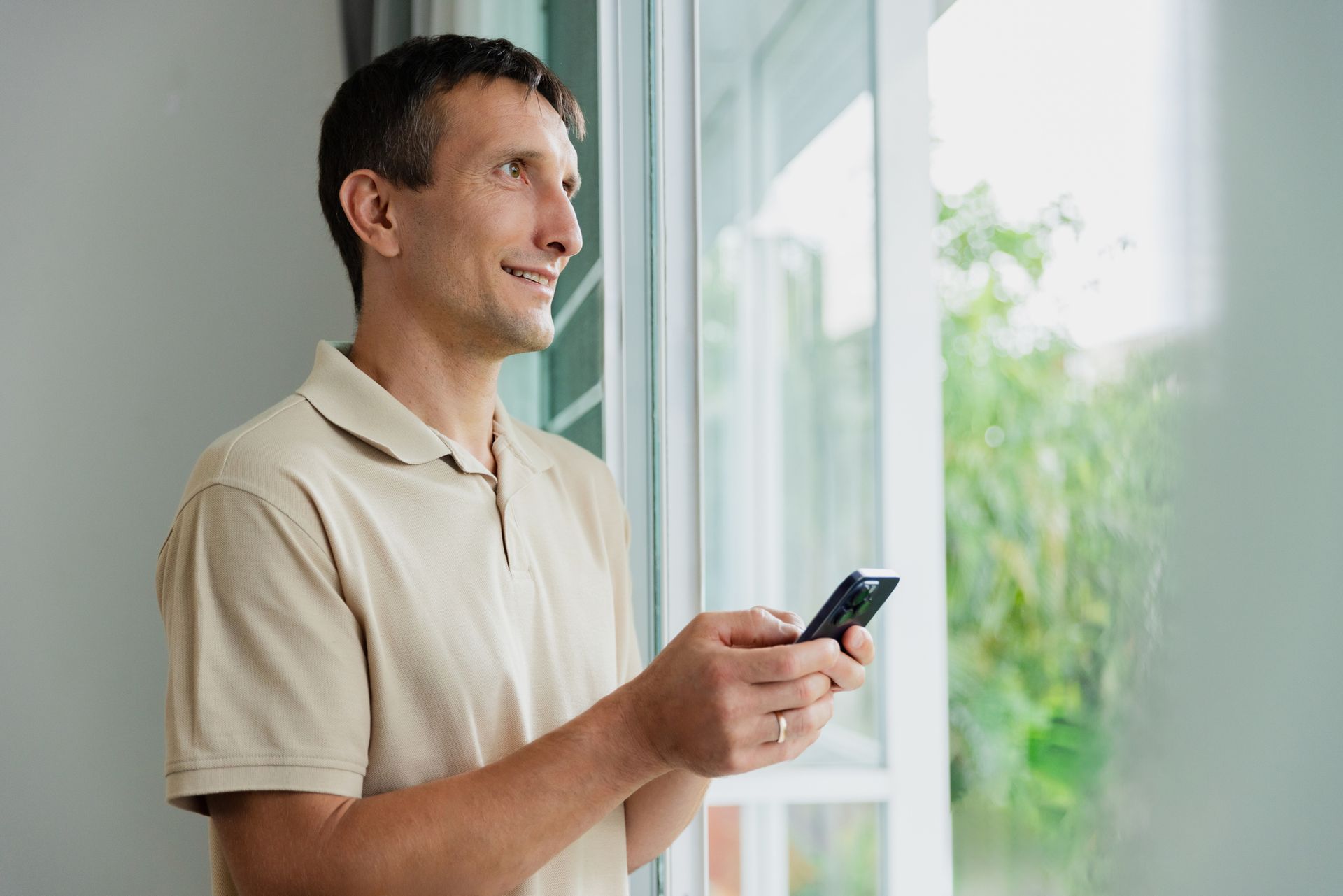 A man is standing in front of his window calling for window tinting services. A man is standing in front of his window calling for window tinting services.