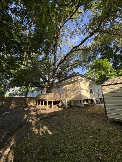 There is a large tree in the backyard of a house.
