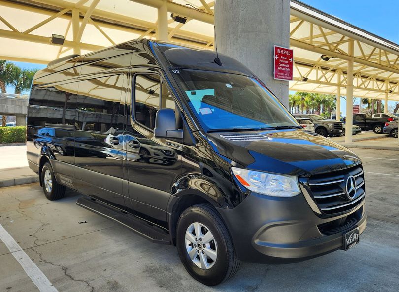 A black mercedes benz sprinter van is parked in a parking lot.