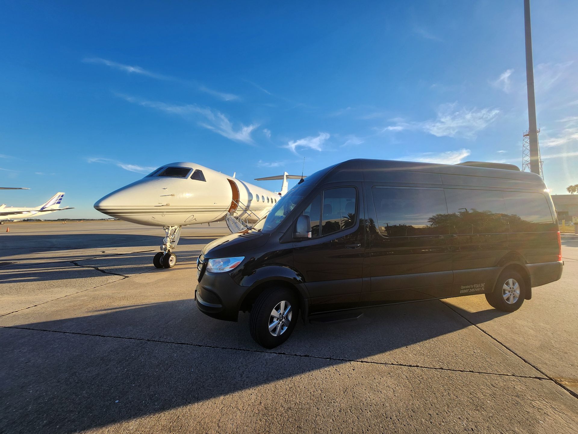 A van is parked in front of a private jet.