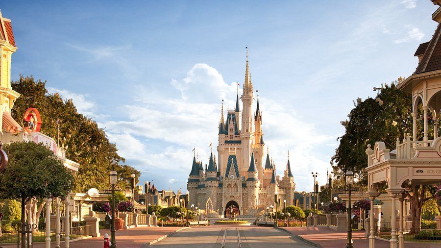 A large castle is sitting in the middle of a park surrounded by trees.