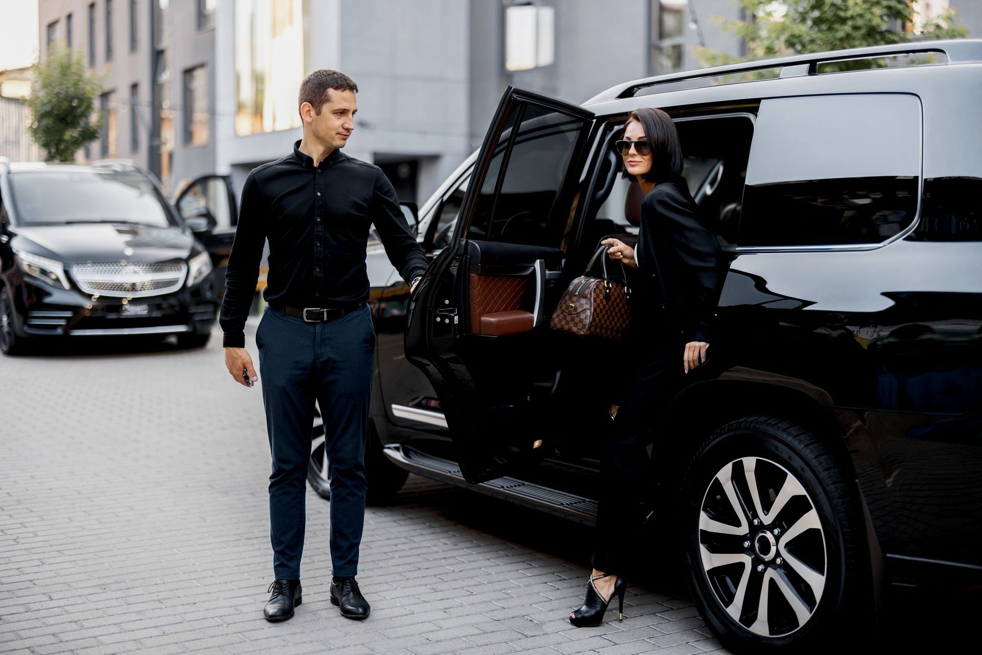 A man is helping a woman get out of a car.