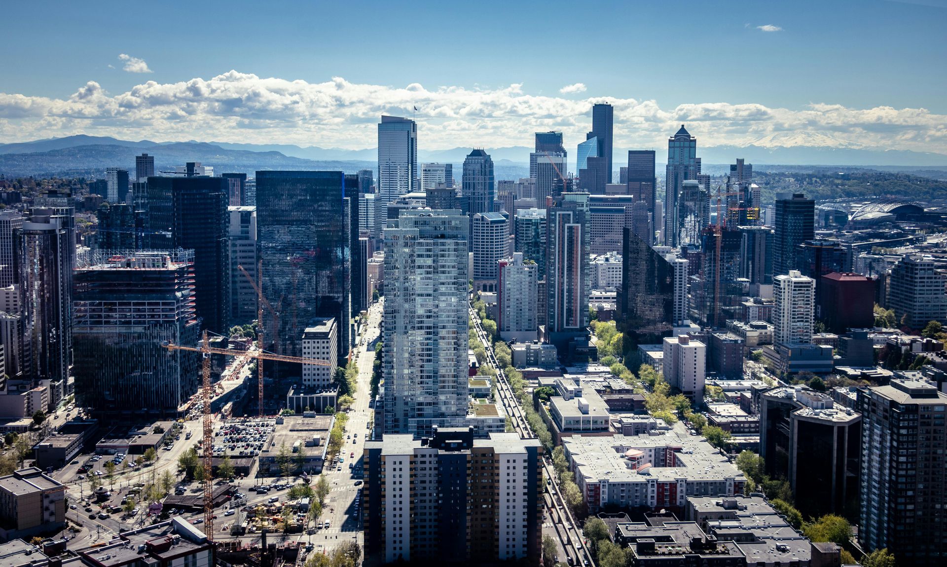 City skyline with tall buildings, blue sky, and a bright sunny day.
