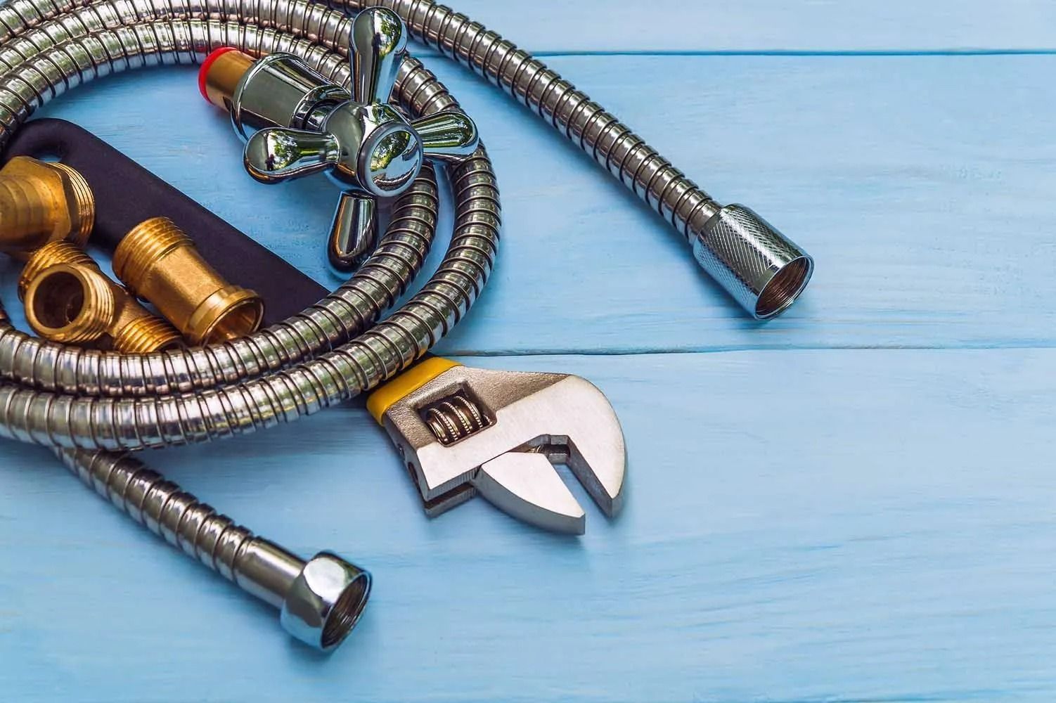 A plumber is working on a pipe with a wrench.