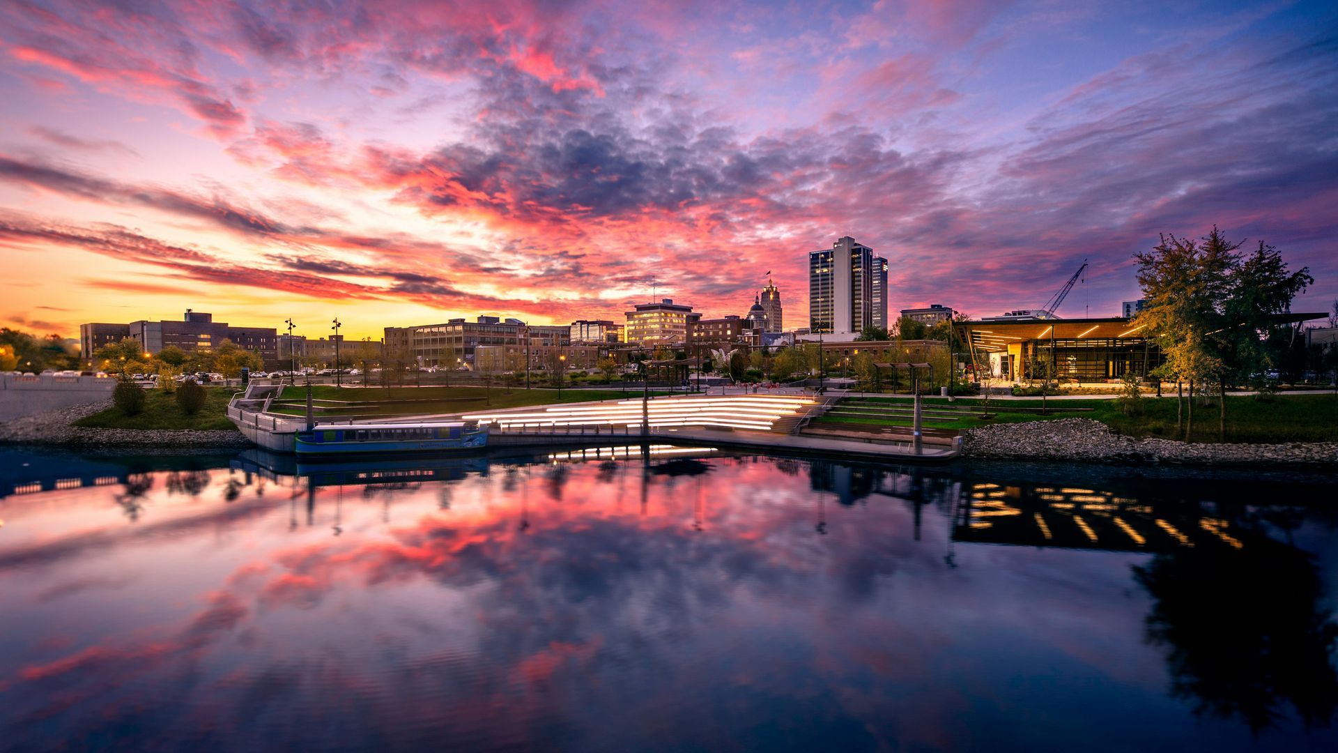Historic building on a beach with arched openings, under a partly cloudy sky. People walk on the sand.