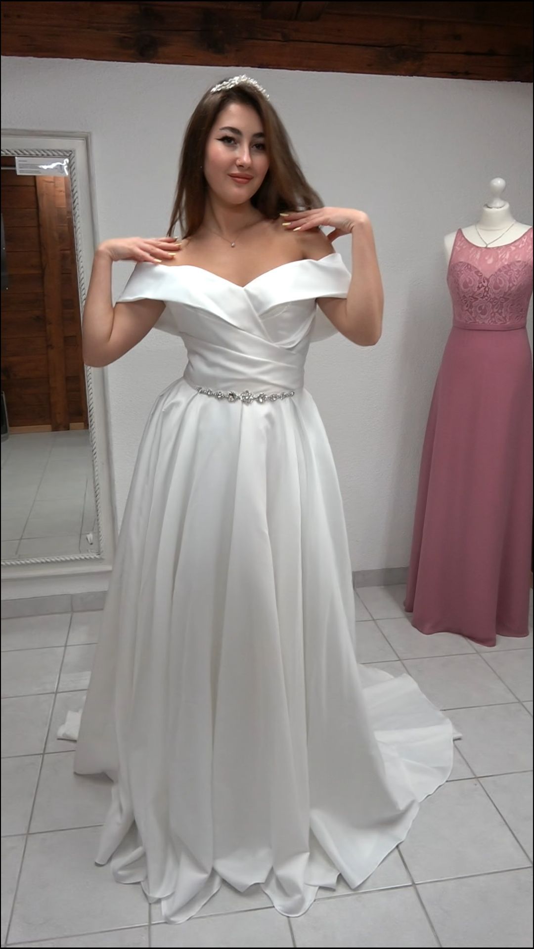 Eine Frau in einem weißen Brautkleid steht vor einem Spiegel.