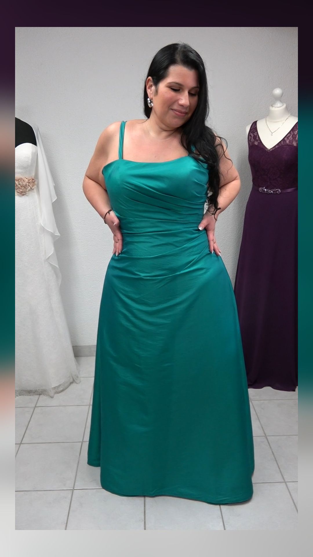 Eine Frau in einem grünen Kleid steht in einem Raum.