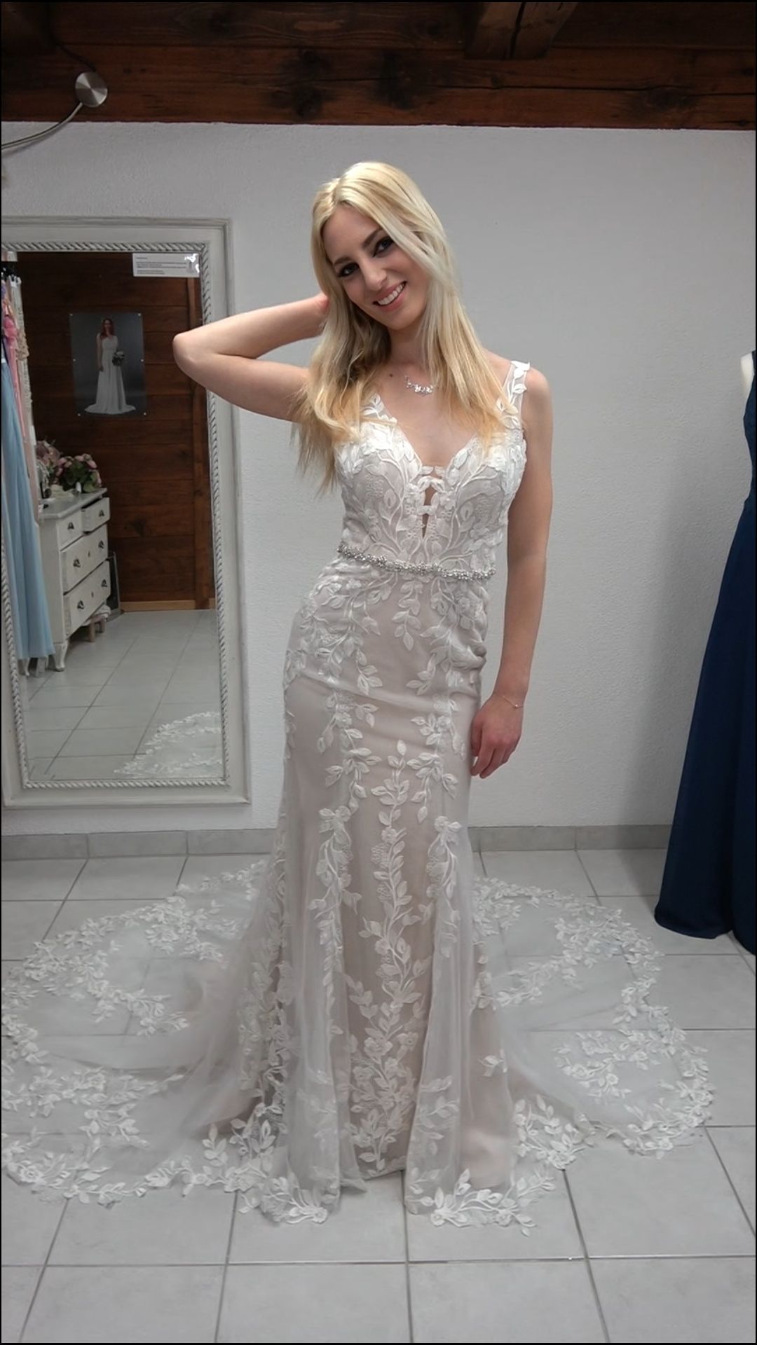 Eine Frau in einem Brautkleid steht vor einem Spiegel.