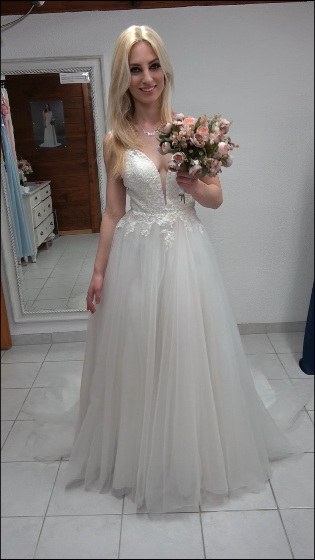 Eine Frau in einem Brautkleid hält einen Blumenstrauß.