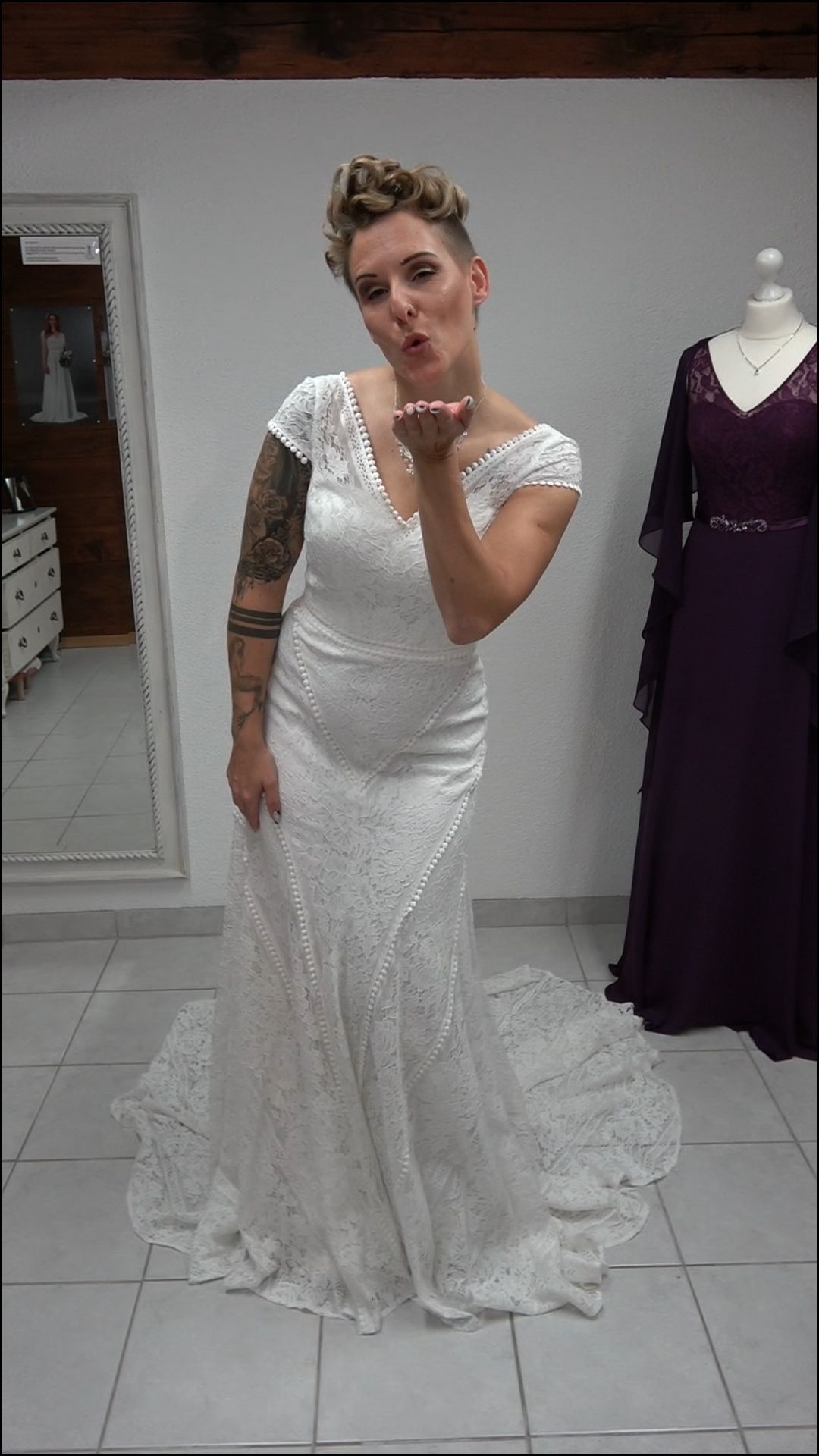 Eine Frau in einem Brautkleid wirft einen Kuss zu.