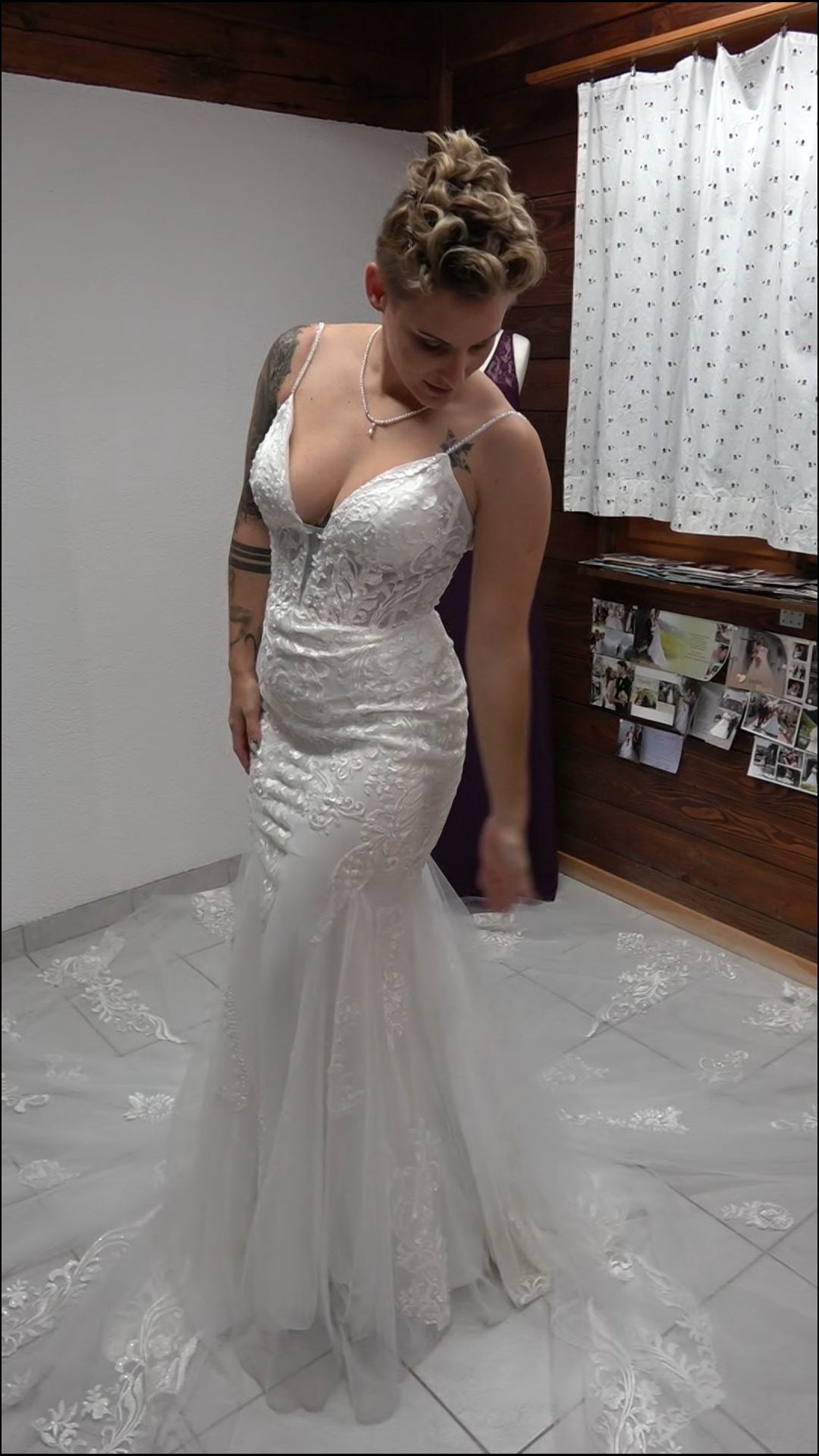 Eine Frau probiert in einem Zimmer ein Brautkleid an.