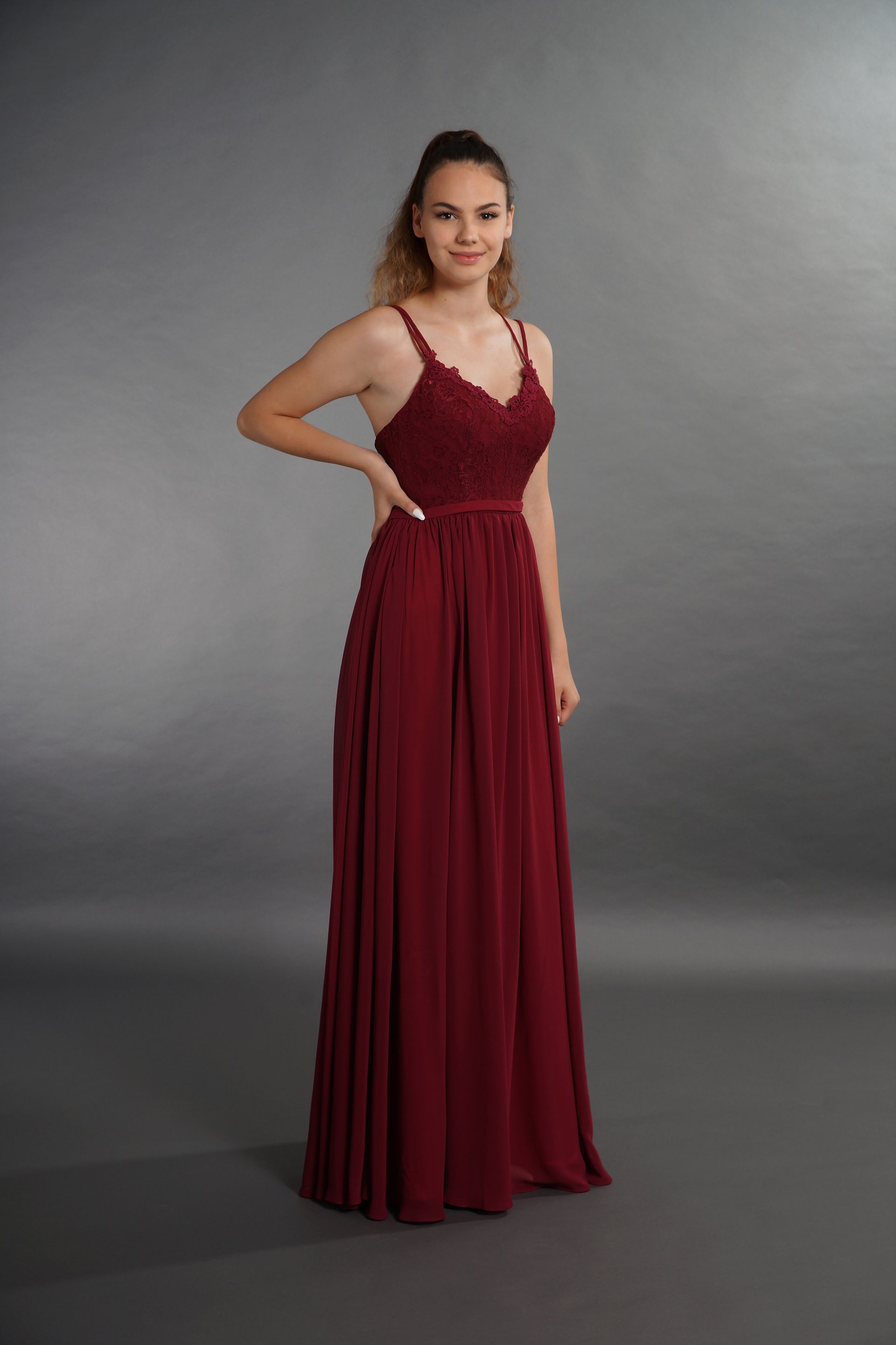 Eine Frau in einem langen roten Kleid steht da.