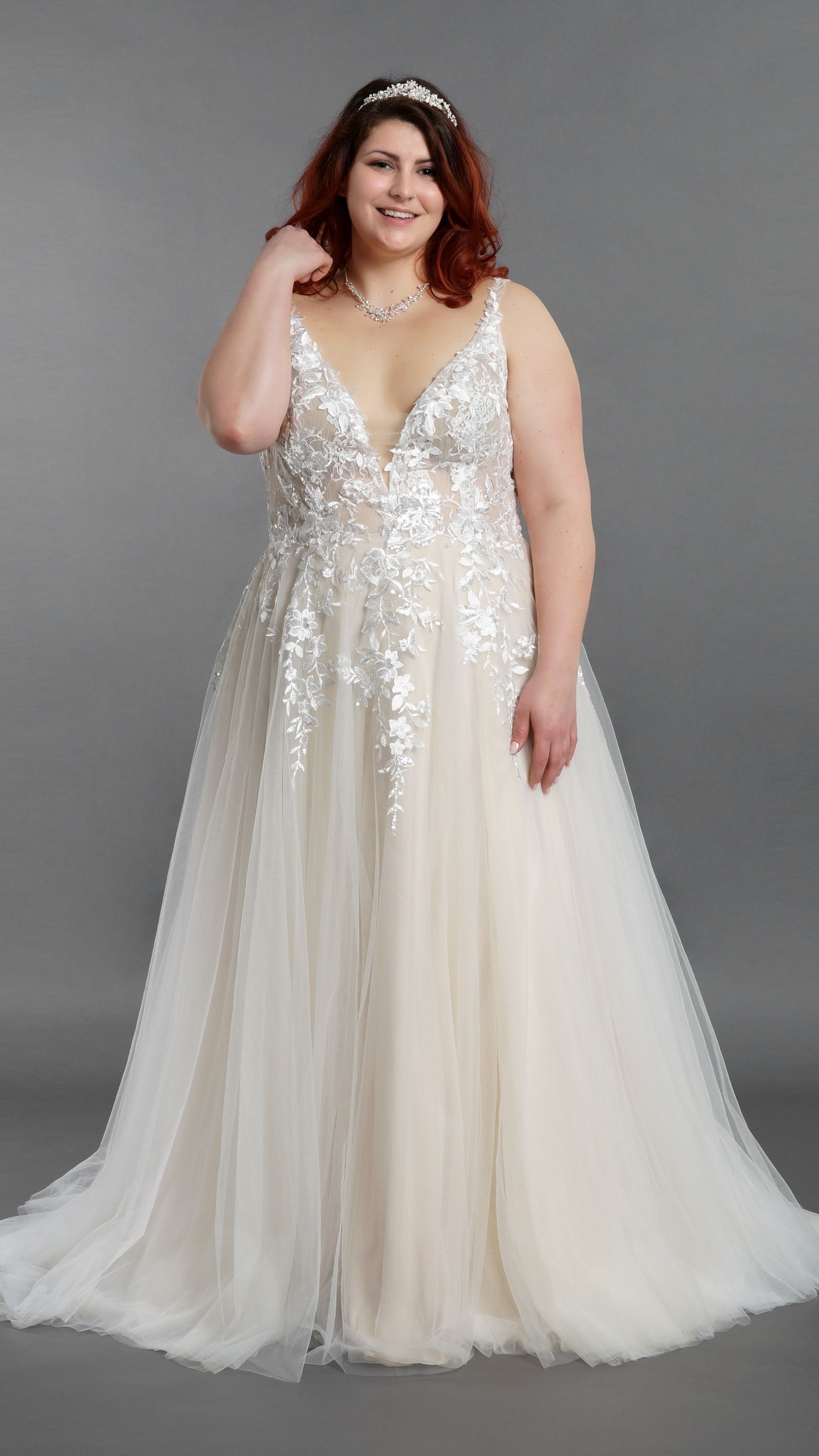 Eine Frau mit Übergröße trägt ein weißes Brautkleid.