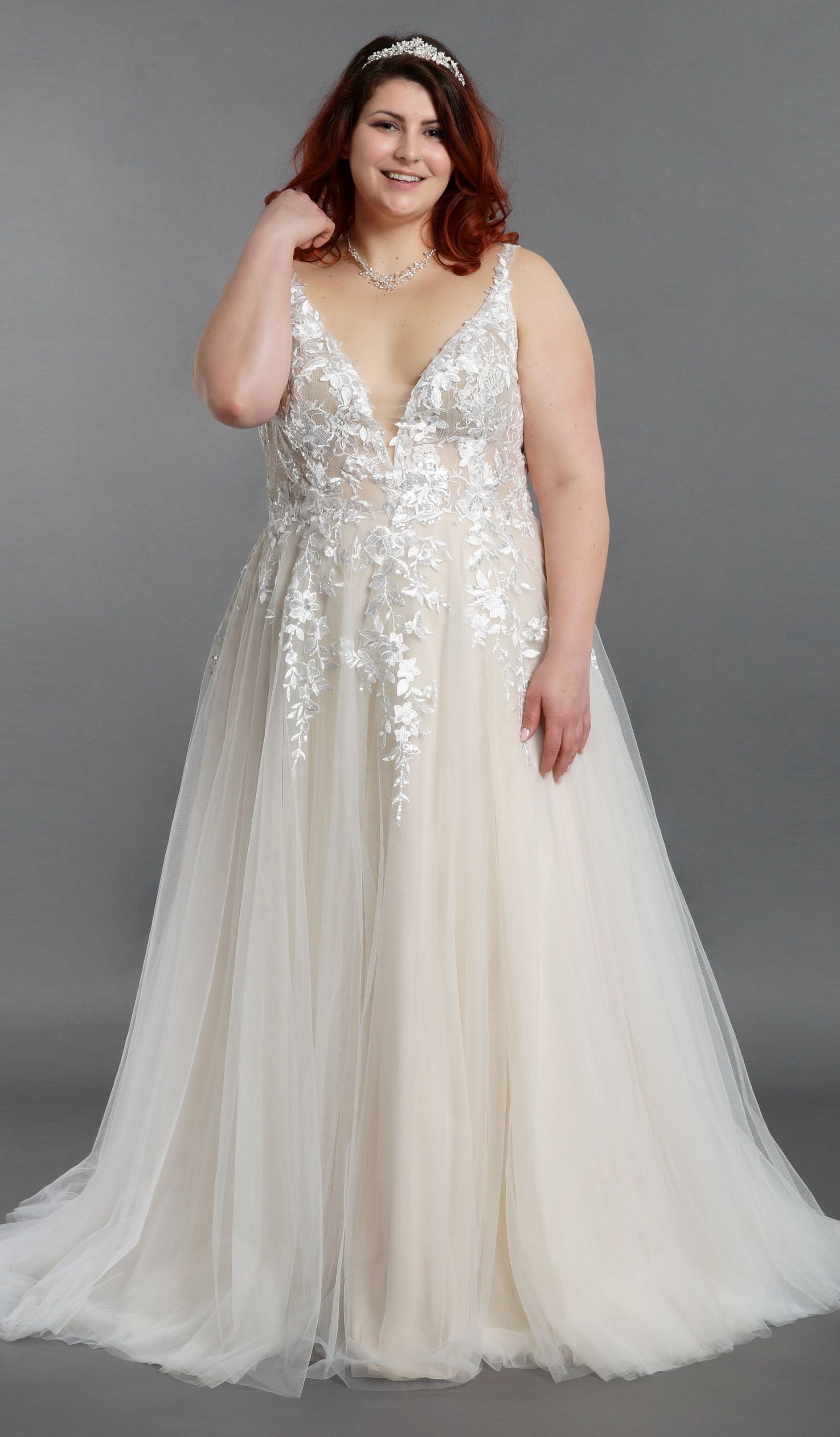 Eine Frau mit Übergröße trägt ein weißes Brautkleid.